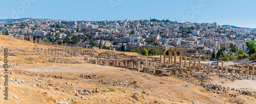 A panorama view across a colonnaded street in the ancient Roman settlement of Gerasa in Jerash, Jordan in summertime