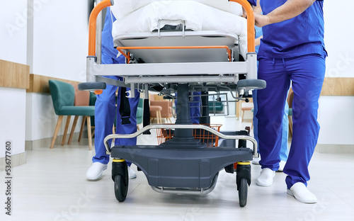 Medical staff pushing patient on medical gurney at emergency department, bottom view. Hospital emergency and healthcare workers