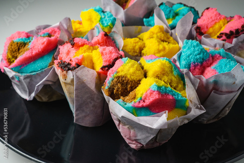 colour full traditional steam cup cake, indonesian bolu kukus on black plate