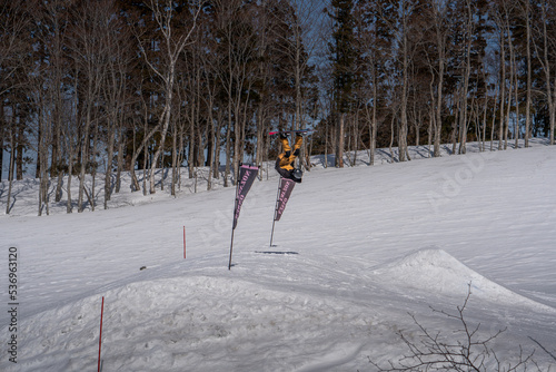 Person Jumping in the snowboard doing a front flip in the snowpark of Nozawa Onsen, Japan