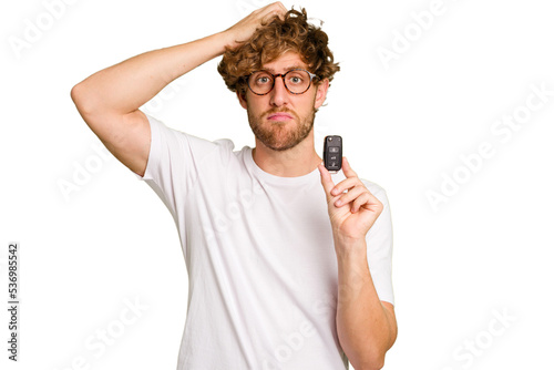 Young caucasian man holding car keys isolated on white background being shocked, she has remembered important meeting.