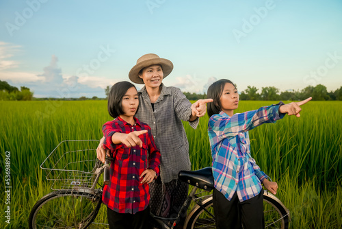 Mother and daughter looking rice field on flooding in countryside