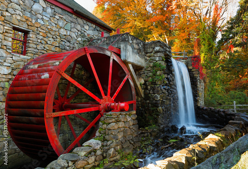 The Wayside Inn Grist Mill with water wheel and cascade water fall in Autumn at sunrise, Sudbury Massachusetts USA