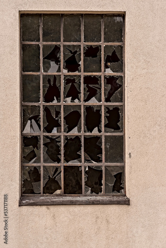 Okno opuszczonego budynku fabrycznego z " malowniczo " wybitymi szybkami . Opuszczony zakład przemysłowy ( fabryka) .