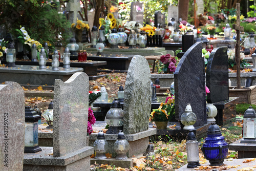 Cmentarz jesienią z alejką grobów bliskich. 