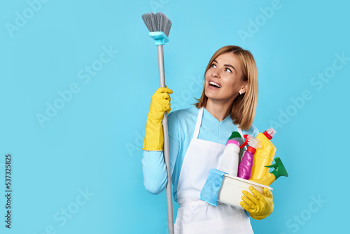 woman in gloves holding bucket of detergents and broom