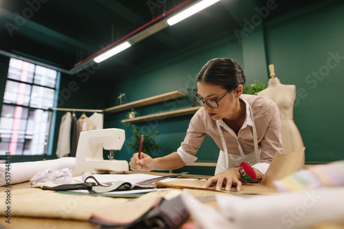 Female fashion designer drawing a design sketch in her workshop