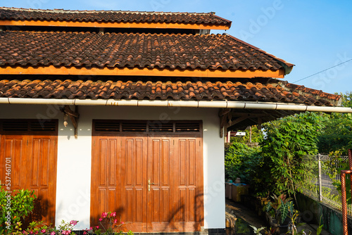 traditional thai house, Shop house with wooden doors, red clay tile roof and Stacked Roof Construction.