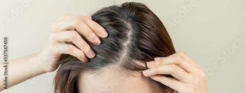 Damaged Hair, face serious asian young woman worry looking at scalp in mirror, hand in break into front hair loss, thin problem symptom at home. Health care shampoo beauty, isolated on background.