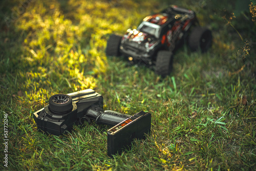 The remote control of the radio-controlled machine lies on the grass. Basics of driving a car for a child. A toy for boys. Control of the toy by radio signal from the remote control.