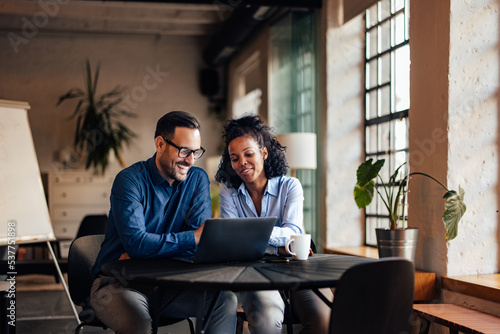 Business people working at the office, using a laptop together.