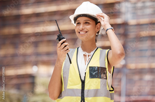 Woman engineer, construction and communication with walkie talkie, technology and safety check working. Construction worker, industry and protection helmet, radio supervision and leadership.