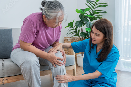 Physical therapist Asian woman, doing leg physiotherapy for elderly woman, to treat osteoarthritis and nerve pain in the leg, to nursing home and health care concept.