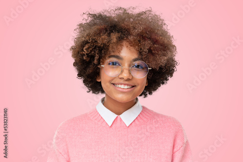 Smiling african schoolgirl wearing pink sweater and glasses isolated on pink