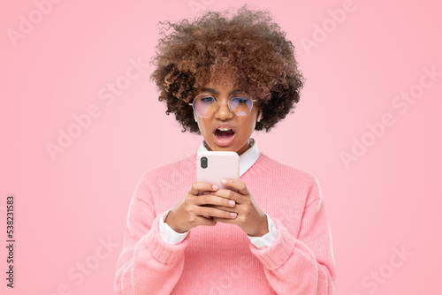 African girl cringe and looking at phone screen with disgust, reading inappropriate content