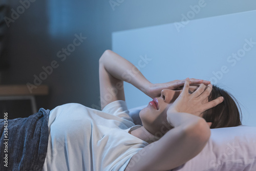 Asian women opened eyes lying on the bed have an insomnia problems.