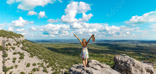 Woman tourist on mountain peak enjoying panoramic view of valley ( languedoc in France)