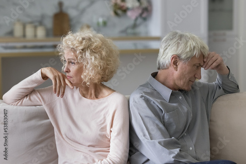 Unsuccessful relationships, failed marriage, relations break up, misunderstanding. Silent sad older married couple sit on sofa separately ponder over problems feel dissatisfied, thinking about divorce