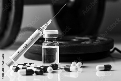 dumbbells, syringe with needle, pills and vial with steroids. illegal doping in sport concept