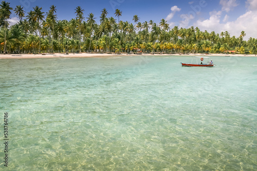 Carneiros idyllic beach with rustic boat at sunny day, in Northeastern Brazil