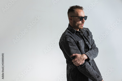 side view of casual man holding arms in fashion pose