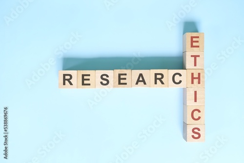 Research ethics concept. Crossword puzzle flat lay typography in blue background