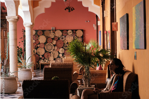 Girl waiting in a chair in a hall of an hacienda 