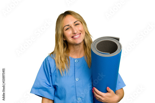 Young caucasian physiotherapist woman holding a mat isolated on green chroma background happy, smiling and cheerful.