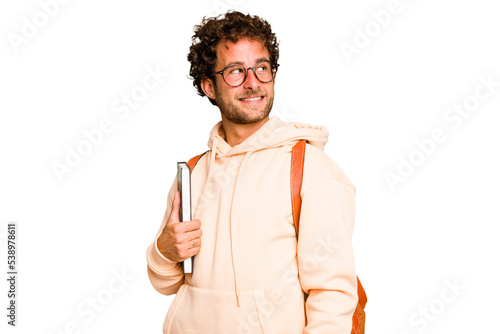 Young caucasian student man isolated looks aside smiling, cheerful and pleasant.