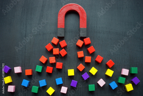 The magnet attracts colored cubes. Leads generation and acquisition concept.