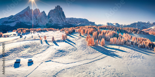 Panoramic winter view from flying drone of Alpe di Siusi village with Plattkofel peak on background. Splendid morning view of Dolomite Alps. Bright outdoor scene of Ityaly, Europe.