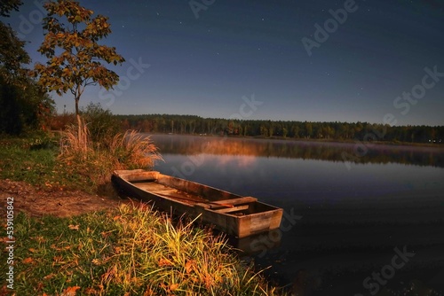Łódka nad jeziorem w nocy.