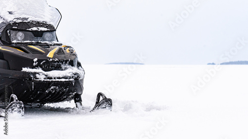 Panoramic background with snowmobile on ice of frozen lake on winter day