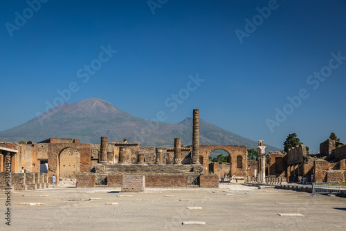 The ruins of Pompeii with a clear blue sky over Mount Vesuvius in Italy.