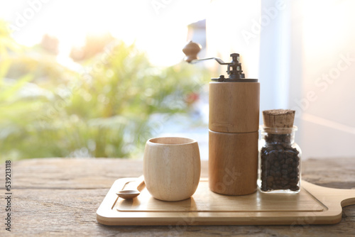 wooden coffee grinder and wooden cup with coffee bean in glass bottle