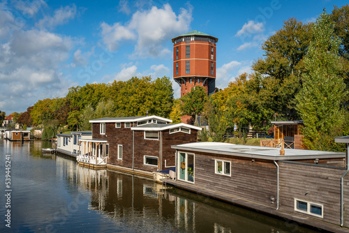 Scenery with old water tower from 1892 converted into apartment complex along the canal with houseboats in the city of Zwolle, The Netherlands