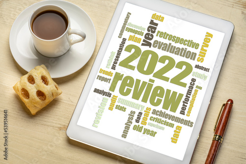 2022 year review word cloud on a digital tablet, flat lay with a cup of coffee, end of year business analysis concept
