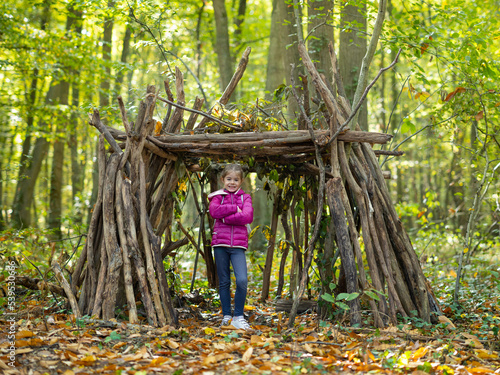 une petite fille et sa cabane en bois en forêt