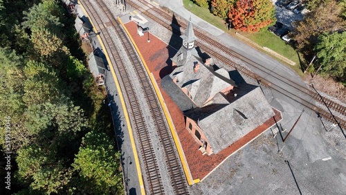 Rail train station depot in Point of Rocks Maryland beside forest hillside, Potomac River and small town American neighborhoods