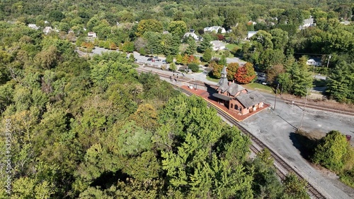Rail train station depot in Point of Rocks Maryland beside forest hillside, Potomac River and small town American neighborhoods