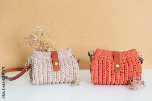 Woman trendy crochet purse on beige background. Fashion concept