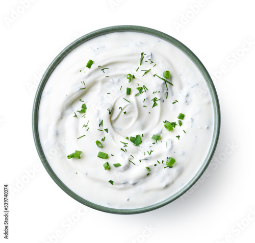 Green bowl of sour cream dip sauce with herbs