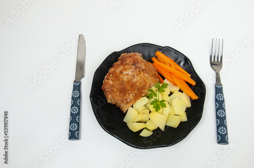  salad dish with potato, carrot, lettuce and breaded pork steak