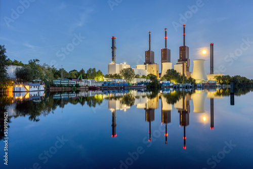 A combined heat and power plant in Berlin at night with a perfect reflection in the water