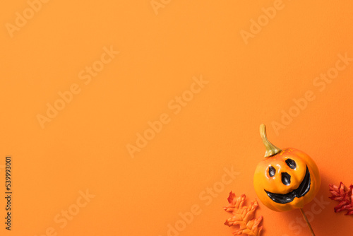Creative Halloween design concept background with pumpkin, autumn leaves and copy space.