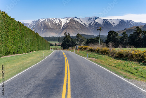 Landscape of Canterbury, South Island New Zealand, taken on the Inland Scenic Route 72, with wild bushes and snow-covered Alps in the background.