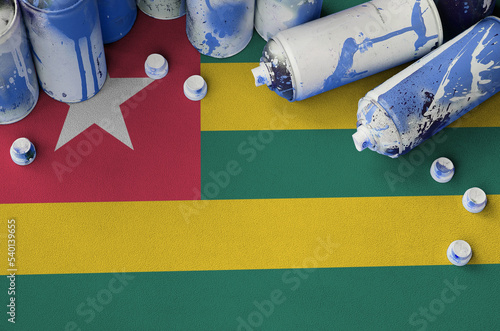 Togo flag and few used aerosol spray cans for graffiti painting. Street art culture concept