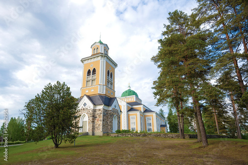 View of the ancient bell tower and wooden church in Kerimyaki on a June cloudy morning. Finland