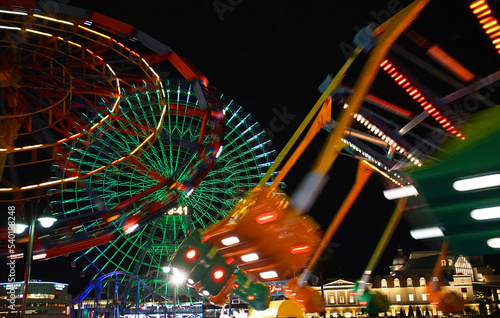 Night view of amusement park rides with many colored lights