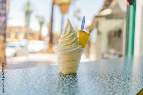 pineapple dole whip frozen yogurt ice-cream with a pineapple wedge on a countertop
